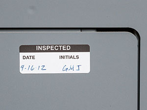 Grey panel with an inspection label, dated and initialed.