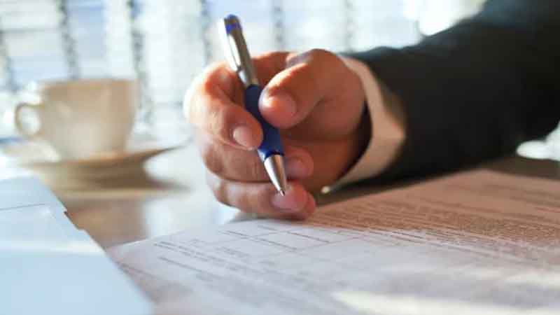 A person reviewing a document and marking it with pen.